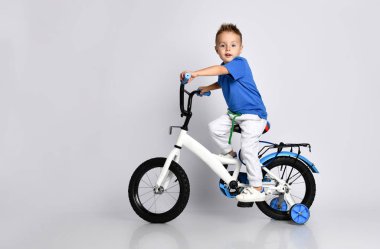 Genç çocuk izole edilmiş arka planda bisiklet sürmekten mutlu.