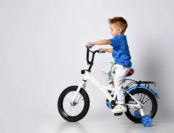 Young boy happily riding on a bicycle on isolated background — Stock Photo, Image