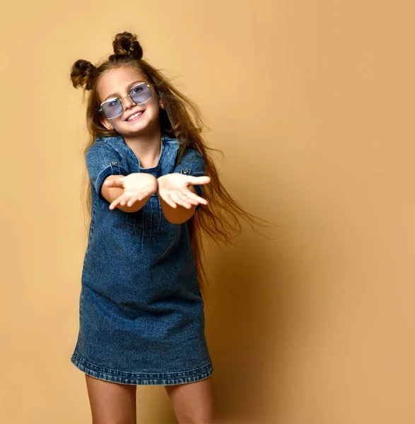 Schattig meisje in jeans sundress en zonnebril poseren op camera. — Stockfoto