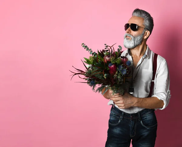 Elegante hombre barbudo de mediana edad con flores. mirando hacia otro lado — Foto de Stock