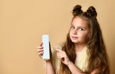 Güzel saç kesimi olan güzel bir kız size içinde krem, parfüm ya da kozmetik ürünler olan bir kutu sunar.