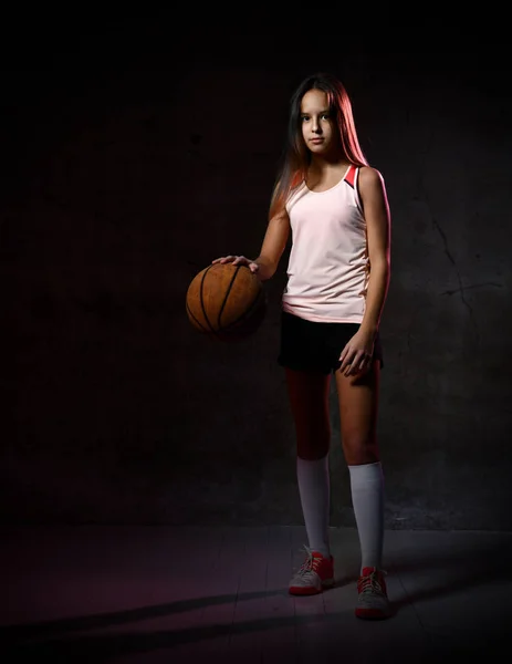 Όμορφη καυκάσια έφηβη με αθλητικά να παίζει μπάσκετ. Αθλητισμός έννοια απομονώνονται σε μαύρο φόντο. — Φωτογραφία Αρχείου