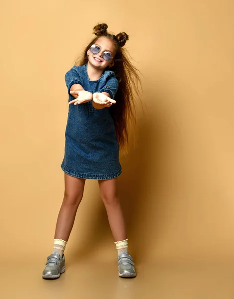 Schattig meisje in jeans sundress en zonnebril poseren op camera. — Stockfoto