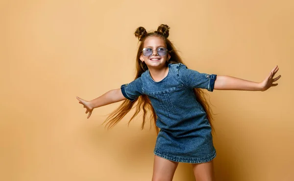 Schattig meisje in jeans sundress en zonnebril poseren op camera. — Stockfoto