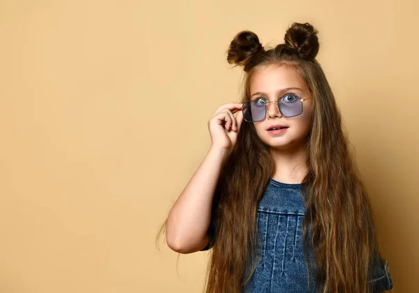 Schattig meisje in jeans sundress en zonnebril poseren op camera. — Stockfoto