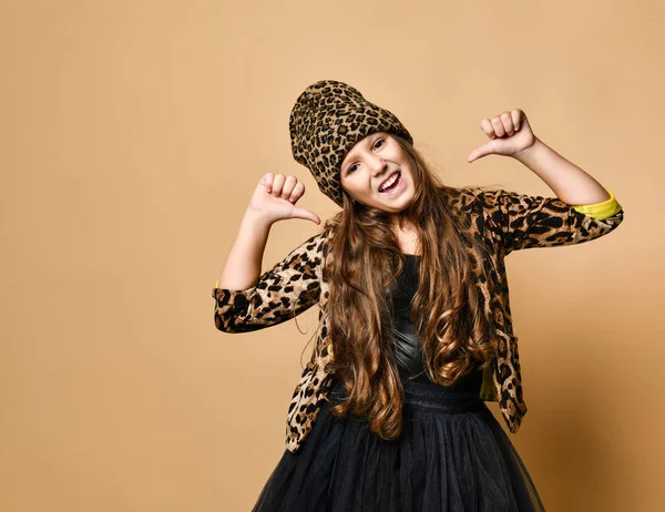 Joven modelo de niña de talla grande en elegante ropa casual de color leopardo y falda negra de pie, sonriendo y señalándose a sí misma — Foto de Stock