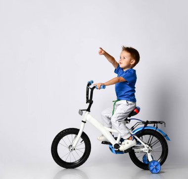 Genç çocuk izole edilmiş arka planda bisiklet sürmekten mutlu.