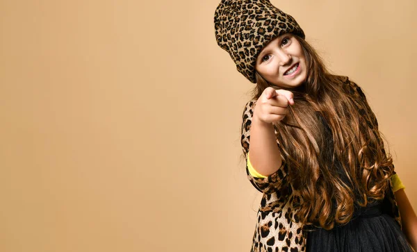 Genç ve cüsseli bir kız model şık bir leopar renginde günlük kıyafetler ve siyah etek giyip kamerayı işaret ediyor. — Stok fotoğraf