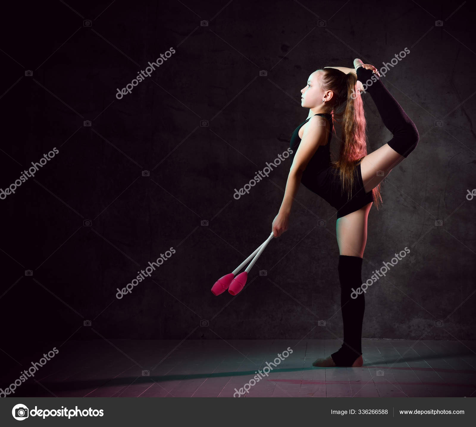 Young smiling girl gymnast in black sport body and uppers standing