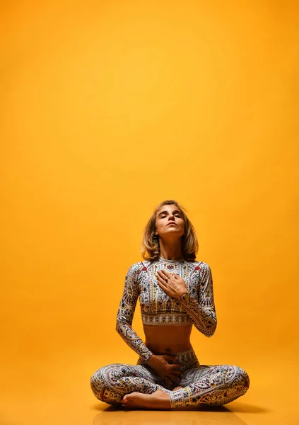 Young attractive woman practicing yoga, working out, wearing sportswear, full length on a yellow background in the studio. — Stock Photo, Image