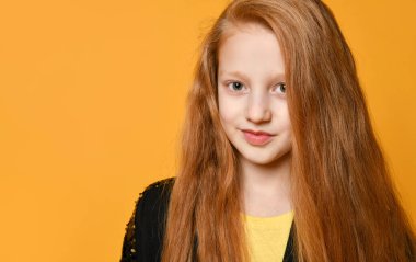 Siyah ceketli kızıl saçlı genç. Gülümsüyor ve sana bakıyor, turuncu stüdyo arka planında poz veriyor. Kapat.