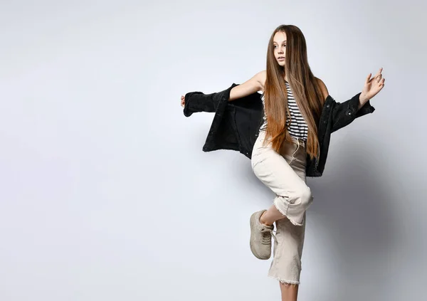 Adolescent in striped t-shirt, black denim jacket, pants and sneakers. She is posing isolated on white background. Close up — ストック写真