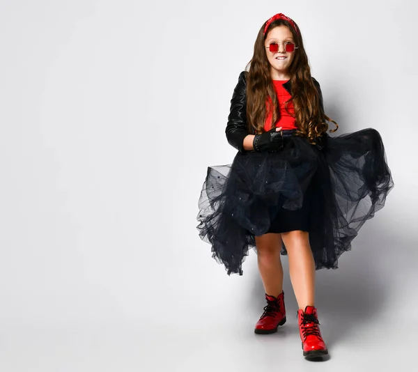 Joven modelo de chica positiva de talla grande en ropa de estilo rock brillante, botas rojas y gafas cuadradas dtanding y sintiéndose emocionado — Foto de Stock