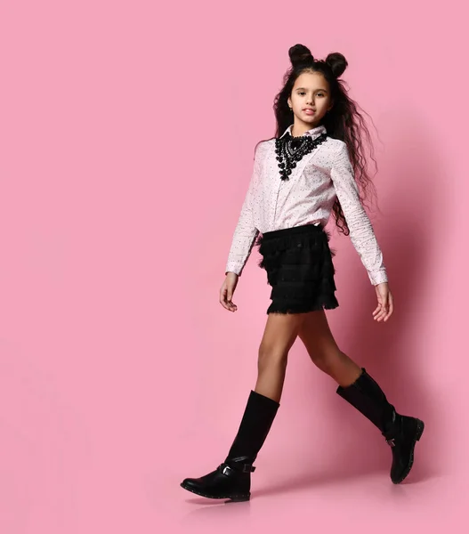 Chica joven en ropa de moda y accesorios caminando sobre fondo rosa — Foto de Stock