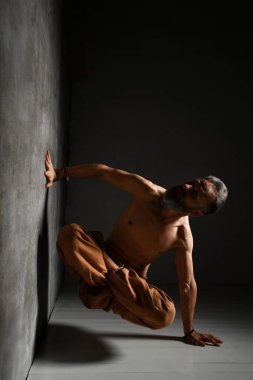 Kırmızı kazıklı, siyah sutyen ve deri etekli obez kadın. Dans ediyor, beyaz arka planda yalnız poz veriyor.