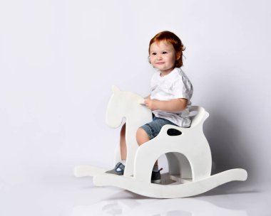 Beyaz t-shirt şortlu kızıl çocuk. Ananas şeklinde plastik şişeden kokteyl içmek, beyaz üzerine izole edilmiş poz vermek.