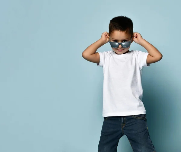 Portrét mladého usmívajícího se chlapce v bílé košili na modrém pozadí — Stock fotografie