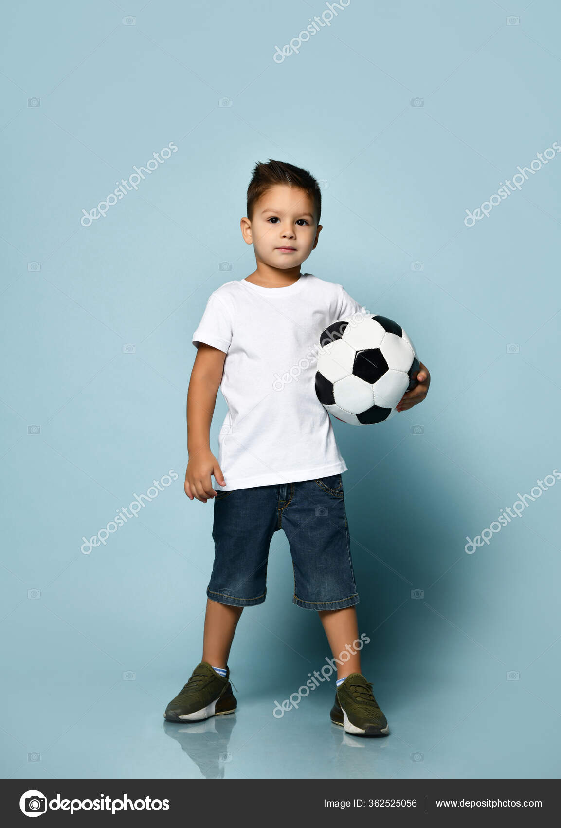 Menino jogando futebol. menino segurando bola