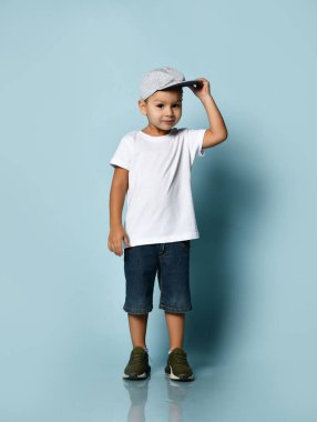 Mavi arka planda beyaz gömlekli, gülümseyen bir çocuğun portresi.