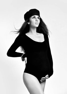 Siyah mayo, şapka ve şapka giyen şık hamile bir kız. Aile ve annelik, spor, modern