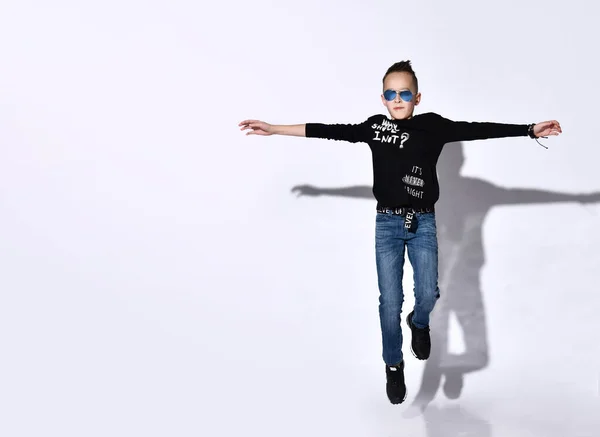 Young boy jumping isolated over white background