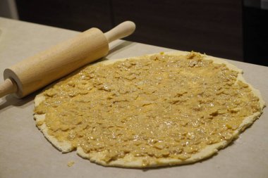 Hamur, çörek, pasta ya da pizzayla çalışmak. Yuvarlak hamuru yuvarlak bir raptiye ve bir tabanla masaya koydum. Ev yapımı hamur işleri, sağlıklı ve lezzetli yemekler.