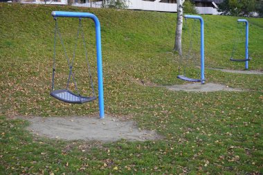 Bahçede ya da parkta çocukların modern salıncağı. Çocuk modası çocuk aktiviteleri. Şehirde yaz tatili var. Tüm aile için dinlenin..