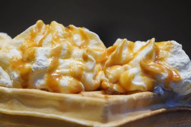 Belçika usulü, kremalı, dondurmalı, üstüne karamel soslu waffle. Yandan bak. Güneşli waffle 'lar. sokak ve fast food