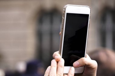 Güneşli bir günde eski şehirde telefonu olan el. Fotoğraf çekin ya da akıllı telefonunuzla video çekin. Avrupa veya Asya 'da seyahat eden blogcu.