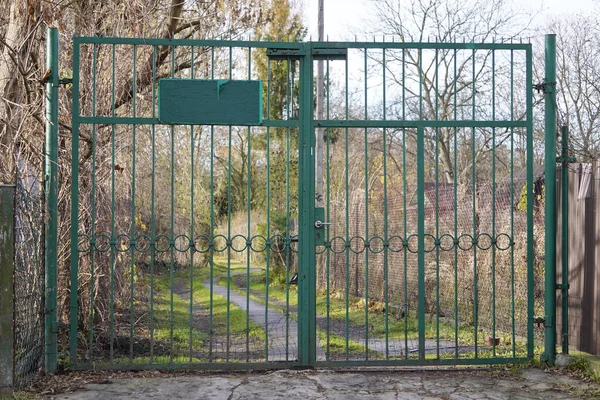 Cerca de ferro verde com um portão na floresta ou entrada de campo é proibido, secreto, território pessoal ou militar. proteção de bens de forasteiros . — Fotografia de Stock