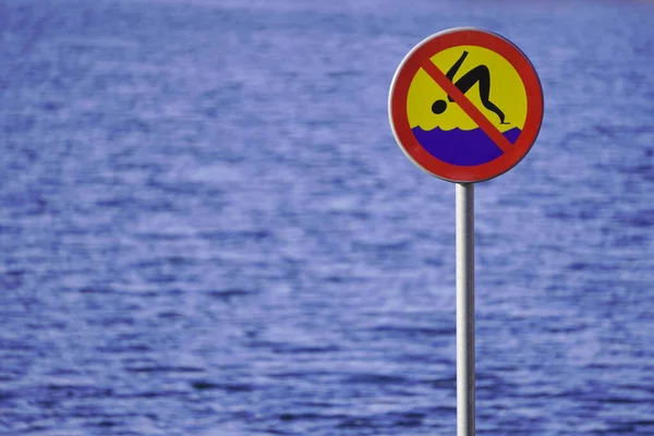 -Schild, das das Tauchen auf dem Hintergrund von Wasser, Fluss oder See verbietet. die Sicherheit der Menschen, flaches Gewässer. — Stockfoto