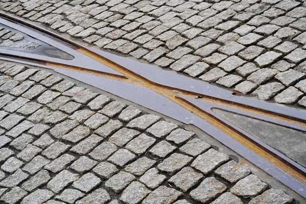 Intersection of rusty rails in the old town on a road of cobblestones. transport network in the city, trams. — Stock Photo, Image