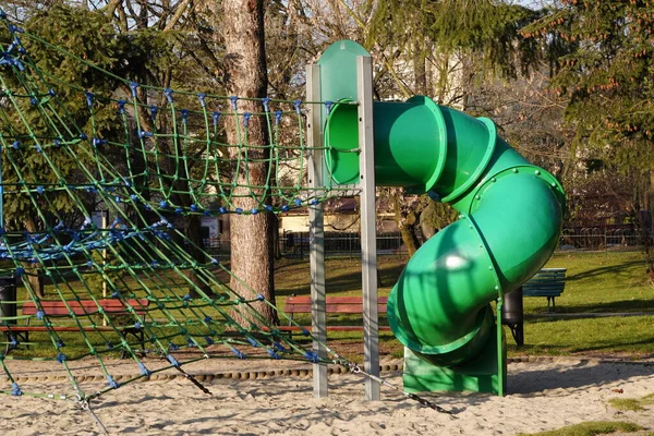 Moderno complexo infantil verde no parque da cidade em um dia ensolarado. Dispositivos para escalar, montando na colina . — Fotografia de Stock