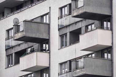 Çiçeklerle süslenmiş balkonları ve loggiaları olan bir bina, uydu anteni. siyah beyaz fotoğraf