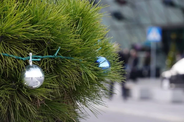 Blauw-witte ballonnen hangen aan kerstboom tegen de achtergrond van wazig modern glas-en-beton luchthaven gebouw in Krakau. decoraties voor de wintervakantie, Kerstmis en Nieuwjaar — Stockfoto