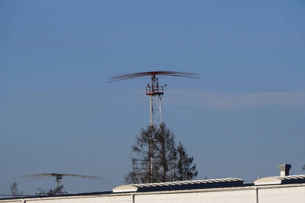 Antena no aeroporto, sistema de radar perto do aeroporto, contra um céu azul claro com uma pequena nuvem. Aeroporto e sistema de navegação de aeronaves. o sistema de aterragem da rota e da trajetória de deslizamento, a segurança das aeronaves — Fotografia de Stock