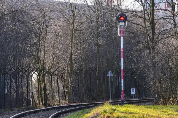 Un signal de sémaphore rouge sur un chemin de fer à voie unique qui tourne — Photo