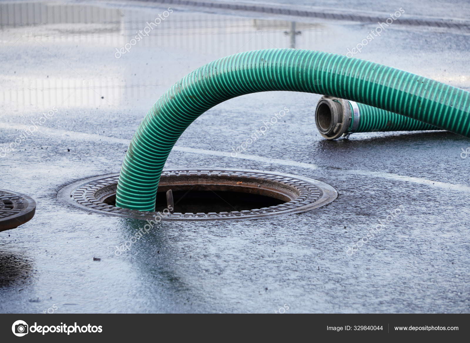 Le tuyau vert épais d'une fosse d'égout, pompage des eaux usées ou des eaux