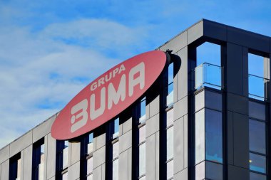 Krakow, Polonya 31.12.2019: modern bir ofis binasının siyah cephesinde logo Grupa buma, açık mavi bir gökyüzünün arka planı, modern mimari, geliştiricinin logosu