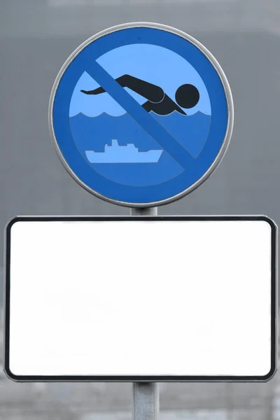 A vertical copy space, white information plate under the forbidding sign about the prohibition of swimming in the city reservoir. Water safety, prohibition signs, urban infrastructure — Stock Photo, Image