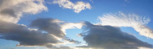 large white fluffy sun-lit clouds against a blue sky. illuminate