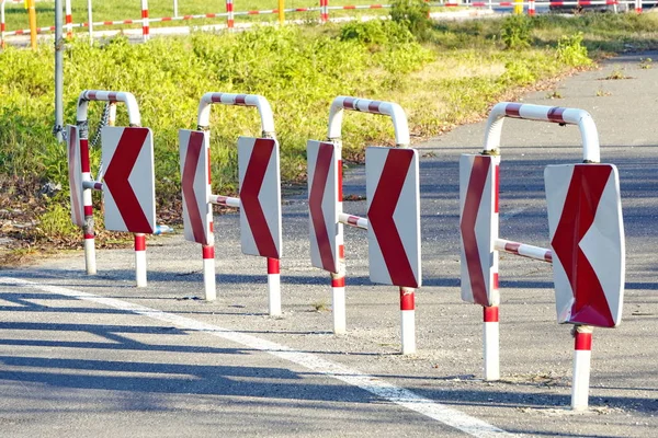 Red and white metal construction of the road fence on the edge of the roadway. Road infrastructure, road safety. regulation of traffic in and out of the city. Bumpers on the road — 스톡 사진