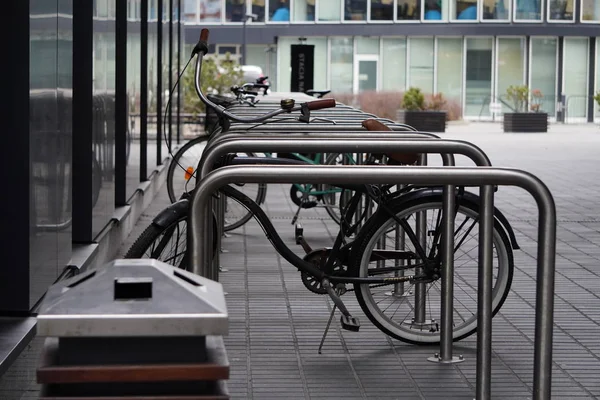 Uma bicicleta velha é fixada a uma estrutura metálica para bicicletas de estacionamento ou scooters, transporte ambiental na cidade. Movendo de bicicleta todos os dias. bicicleta no estacionamento de rua ao ar livre — Fotografia de Stock