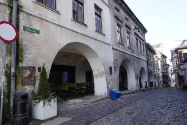 Bielsko Biala, Polonya 14.01.2020: kentte eski bir kaldırımlı sokak, reklam kafeleri ve dükkanları, uzakta bir kişi. Alt manzara, kaldırım taşlarına yakın çekim. Klasik sokak.