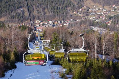 Szczyrk, Polonya 15.01.2020: Sarı kaplı bir kabin veya kapaklı dağlardaki halat boş bir teleferik. Asansör dağa çıkıyor. Szczyrk, Silezya.