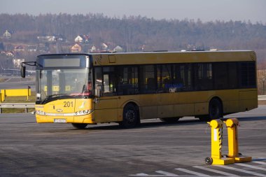 Krakow, Polonya 20.12.2019: Sarı Ryanair otobüsü Solaris havaalanı pisti boyunca gidiyor. Pistteki trafik organizasyonu, havaalanı kontrol servisi.