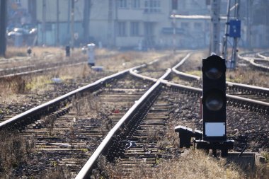 Güneşli ve sisli bir günde eski istasyonda demiryolu rayları, yataklar ve ahşap raylar. Elektrik kabloları olan Polonyalılar, trenler için trafik ışıkları, farklı tren hareketleri organizasyonu..