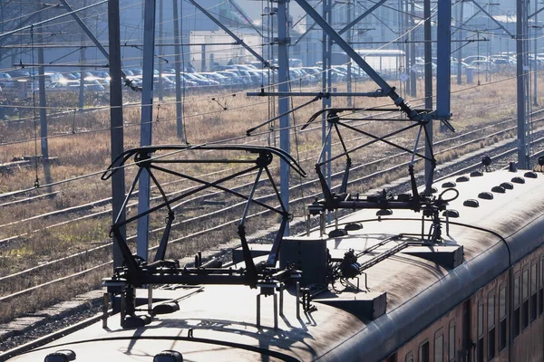 Dach des Zuges mit Stromabnehmern an einem sonnigen nebligen Tag, der mit öffentlichen Verkehrsmitteln unterwegs ist. technische Struktur des Zuges — Stockfoto