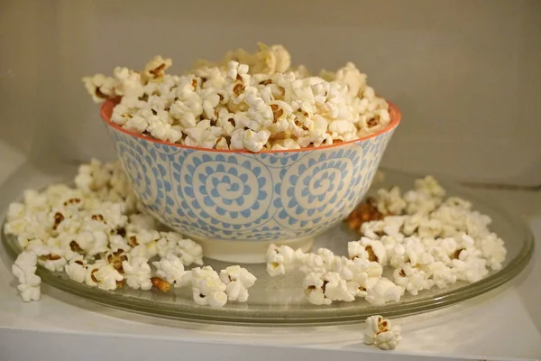 Barevný talíř s popcornem v mikrovlnce, vařit s mikrovlnkou. z talíře se vysypal popcorn. explodující kukuřičná jádra. — Stock fotografie