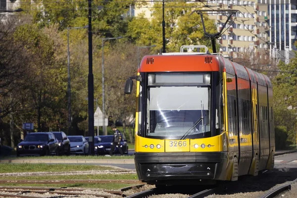 Żółte, jasne, nowoczesne tramwaje zbliżeniowe w słonecznej pogodzie w jesienno-europejskim mieście Warszawa. Wygodny transport publiczny — Zdjęcie stockowe